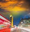 London. City night scene with red bus crossing Westminster. Traffic light trails