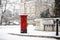 London classic red mailbox  under the falling snow