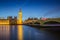 London, England - The Big Ben Clock Tower and Houses of Parliament with iconic red double-decker buses at city of westminster