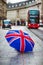 London, England - British umbrella at Regent Street with iconic red double-decker bus and black taxi