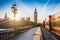 London, England - The iconic Big Ben and the Houses of Parliament with lamp post and moving famous red double-decker buses