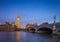 London, England - The iconic Big Ben with Houses of Parliament and traditional red double decker bus on Westminster Bridge