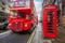 London, England - Iconic blurred black londoner taxi and vintage red double-decker bus on the move