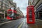 London, England - Iconic blurred red double-decker buses on the move with traditional red telephone box