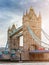 London, England - Tower Bridge, the icon of London on a cloudy morning with traditional red double-decker bus