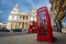 London, England - Traditional red telephone box with iconic red vintage double-decker bus on the move