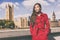 London fashion model in autumn trench coat. Asian woman wearing stylish red fall jacket visiting Westminster and Big Ben