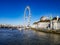 London feery wheel London eye aerial blue warm light pier ferry river thames boats historic building town no cloud water
