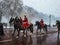 London guard change soldiers buckingham palace riding horses red uniform jacket helmet winter snow snowing armed england