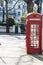 London - March 30: Iconic red phone booth in front of white town houses in Kensington on March 30, 2017