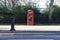 London - March 30: Iconic telephone booth in Kensington Garden in front of park with fence on March 30, 2017