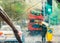 London street scene abstracted by rain on a car windscreen on a rainy day. A red bus can be seen and a man holding cardboard above