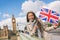 London travel tourist woman showing Union flag Great Britain british UK flag. Asian girl at Big Ben on Westminster