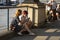 London, U.K., August 22, 2019 - Two candid colleagues take a break sitting on the embankment eating near London Bridge by the