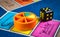 London, UK - 07 April 2019: Close-up of classic board game Trivial Pursuit with black die and colored plastic pieces of different