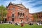 London, UK - 17 April 2022: The red brick building of the Victoria and Albert Museum, Londonand visitors enjoying the John