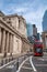 London, UK - 18 April 2022: The exterior of the Bank of England on Threadneedle street, with a red London bus passing by