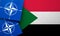 LONDON, UK - August 2022: NATO North Atlantic Treaty Organization military alliance logo on a Sudan flag