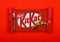 LONDON, UK -DECEMBER 07, 2017: Kit Kat chocolate bar on red. Bars Kit Kat is produced by Nestle company.