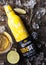 LONDON, UK - FEBRUARY 06, 2019: Steel Bottle of Corona Extra Beer Sunset Edition on wooden background with bottle opener and ice