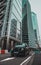 London UK January 2021 Vertical shot of a modern hybrid london taxi passing by on leadenhall street, massive tall skyscrapers