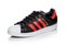 LONDON, UK - JUNE 05, 2019: Adidas Originals Superstar black shoe with red stripes on white background.German multinational