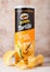 LONDON, UK - JUNE 30, 2018: Pringles potato tortilla chips with cheese on wood. Potato and wheat-based stackable snack.