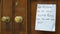 London, UK, March, 20, 2020: Message on paper for postman on wooden door