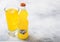 LONDON, UK - SEPTEMBER 28, 2018: Glass and bottle of Fanta Orange soda drink with ice cubes and bubbles on stone kitchen table bac