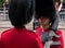 London UK. Two Royal Guard soldiers in red and black uniform and bearskins hats having a friendly chat during Trooping the Colour