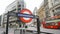 London underground sign on central street with double-decker bus  cars pedestrians