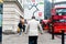 London, United Kingdom - 20 november 2018: old londoner businessman walking in the streets with street sign with arrows in many