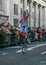 London, United Kingdom - January 1, 2007: Man in clown costume rides unicycle, and waves to cheering crowd, during New Year`s Day