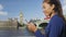London woman on phone using app on smartphone Westminster Bridge