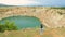 Lone active woman at the edge of abandoned copper mine pit taking photos with camera