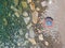 A lone beach umbrella on the stones beach, flat aerial view for background