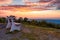 A lone bench looks over the mountain at sunset