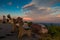 A lone bench and viewing binoculars looks over the mountain at sunset