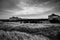 A Lone Building On The Horizon Behind A Large Field of Tall Grass In The Storm In Long Beach Washington in Black And White