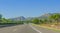 Lone car goes down the highway through coastal foothills and mountains of rural Spain.