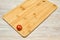 Lone cherry tomato on a cutting board on a table