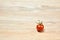 Lone cherry tomato on a wooden table surface