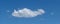 Lone cloud drifts across blue sky panorama