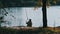 Lone Elderly Fisherman Sitting on the River Bank with a Fishing Rod Catches Fish