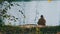 Lone Elderly Fisherman Sitting on the River Bank with a Fishing Rod Catches Fish