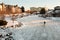 Lone figure skater on a frozen lake at early evening