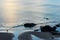 A lone figure walks the calm beach during a summer sunset in Cornwall