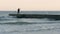 A lone fisherman on the pier in bad weather. Storm at sea.