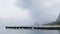 Lone fisherman on a pier in foggy weather