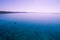 Lone fishing boat in shallow ocean bay waters.